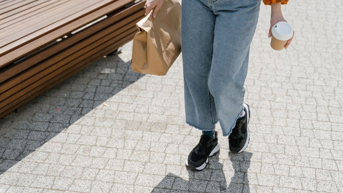 그러면 침대에 누워 쉬는 것이 회복에 더 도움이 될까요? — 직관과 다르게, 코크란 체계적 문헌고찰에 따르면 다리 저림을 동반한 좌골신경통에서는 침상안정과 활동 유지 사이에 통증·기능 회복… · 사진: Casual person in denim jeans walking with takeaway items on a sunn…