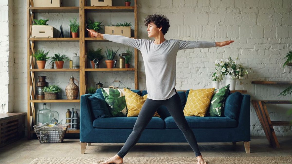 강서구 허리디스크 일상관리 글 대표이미지 · 사진: Woman performs yoga pose in a cozy living room with plants around.