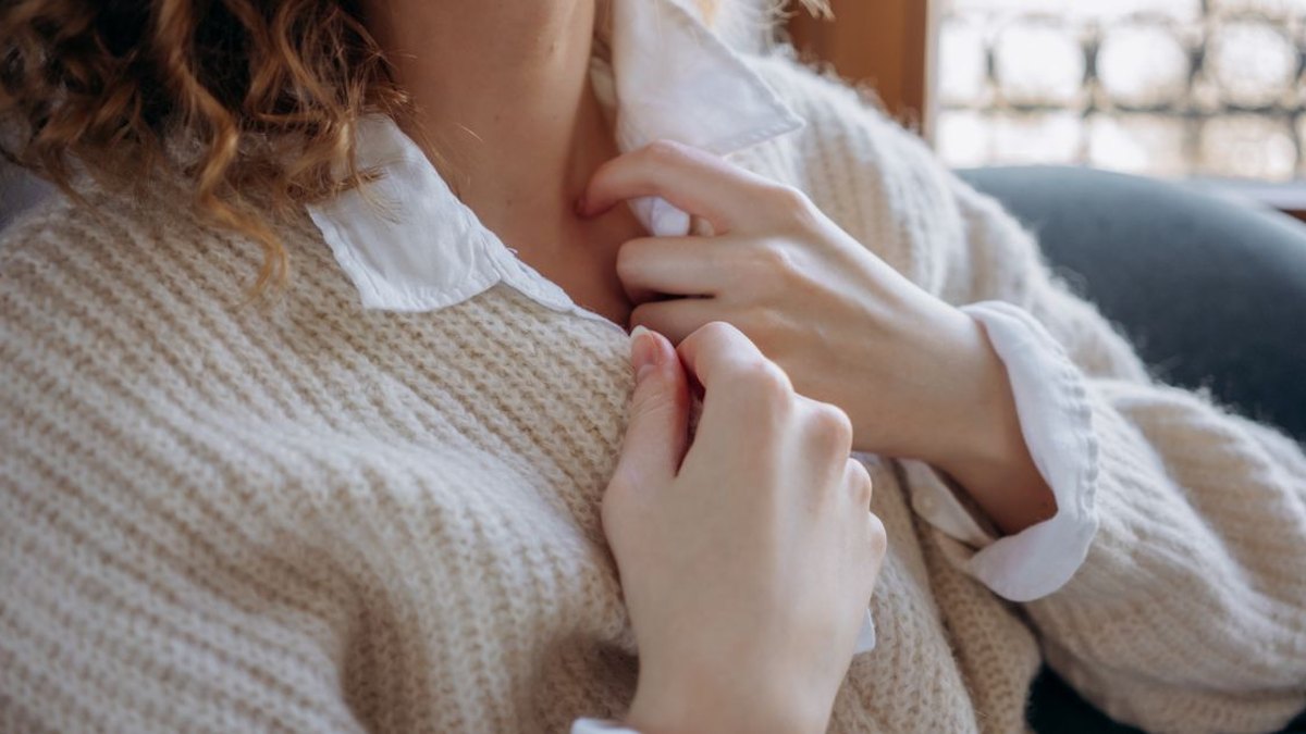 목보조기는 항상 착용해야 하나요? — 그렇지 않습니다. 통증이 심하거나 척수 손상 위험이 있을 때 단기간만 사용하며, 장기간 고정은 오히려 목 근력을 약화시킬 수 있… · 사진: Close-up of hands pulling a soft knitted sweater collar indoors, capturing warm…